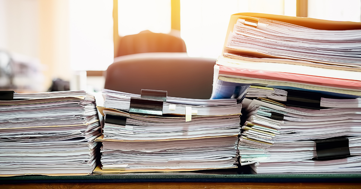 Stacks of immigration case files and documents representing the administrative review process for UK visa refusals.