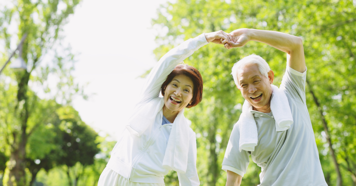 Happy elderly couple exercising outdoors symbolising parents joining family in the UK.