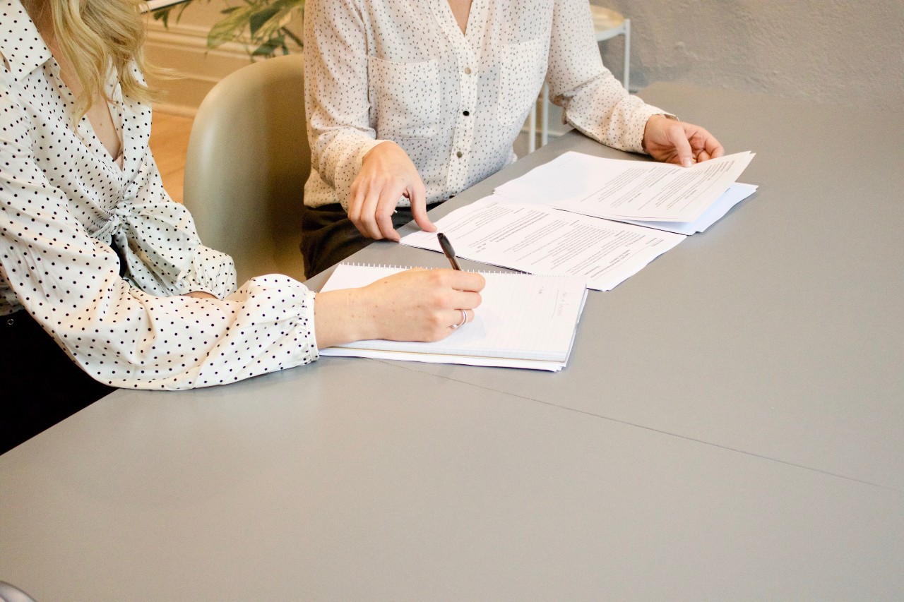 Image of two people looking through some paperwork