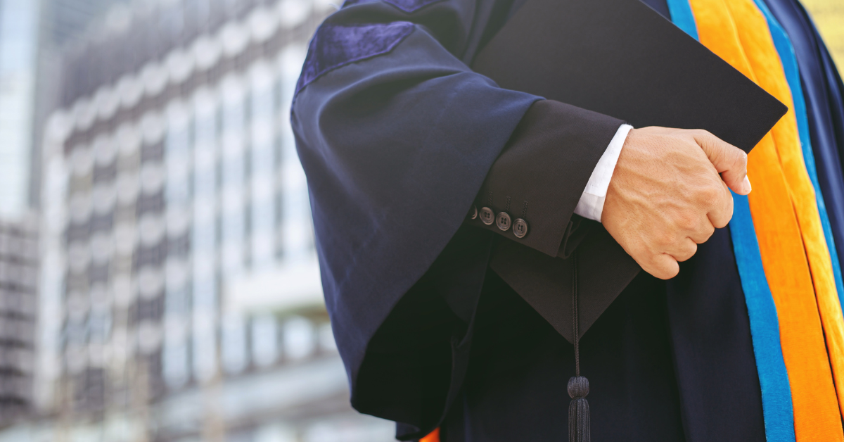 Graduate in academic gown holding cap, representing UK Graduate Visa route review and changes.