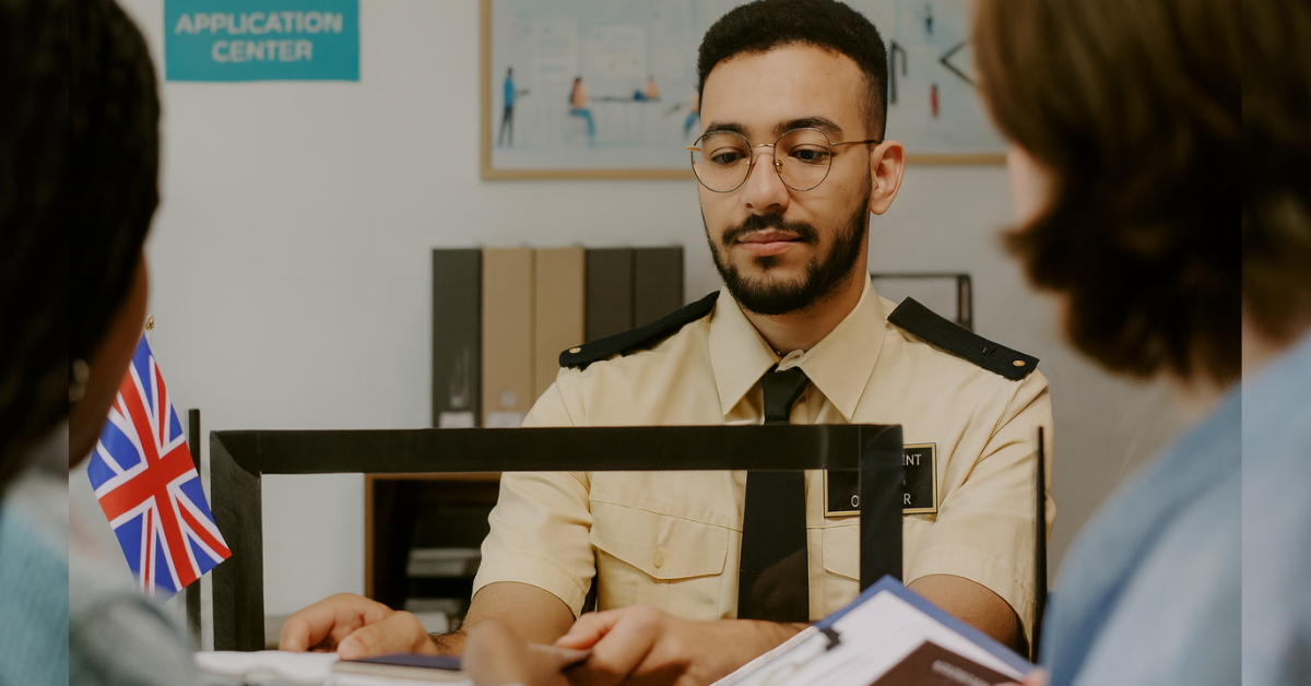 Immigration officer at a UK visa application centre reviewing partner visa documents with a couple applying together.